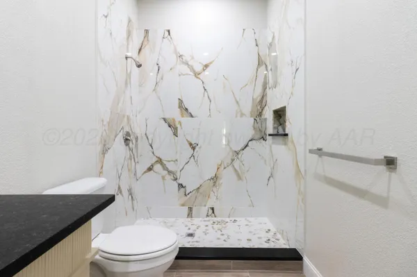 a bathroom with a granite countertop sink toilet and shower