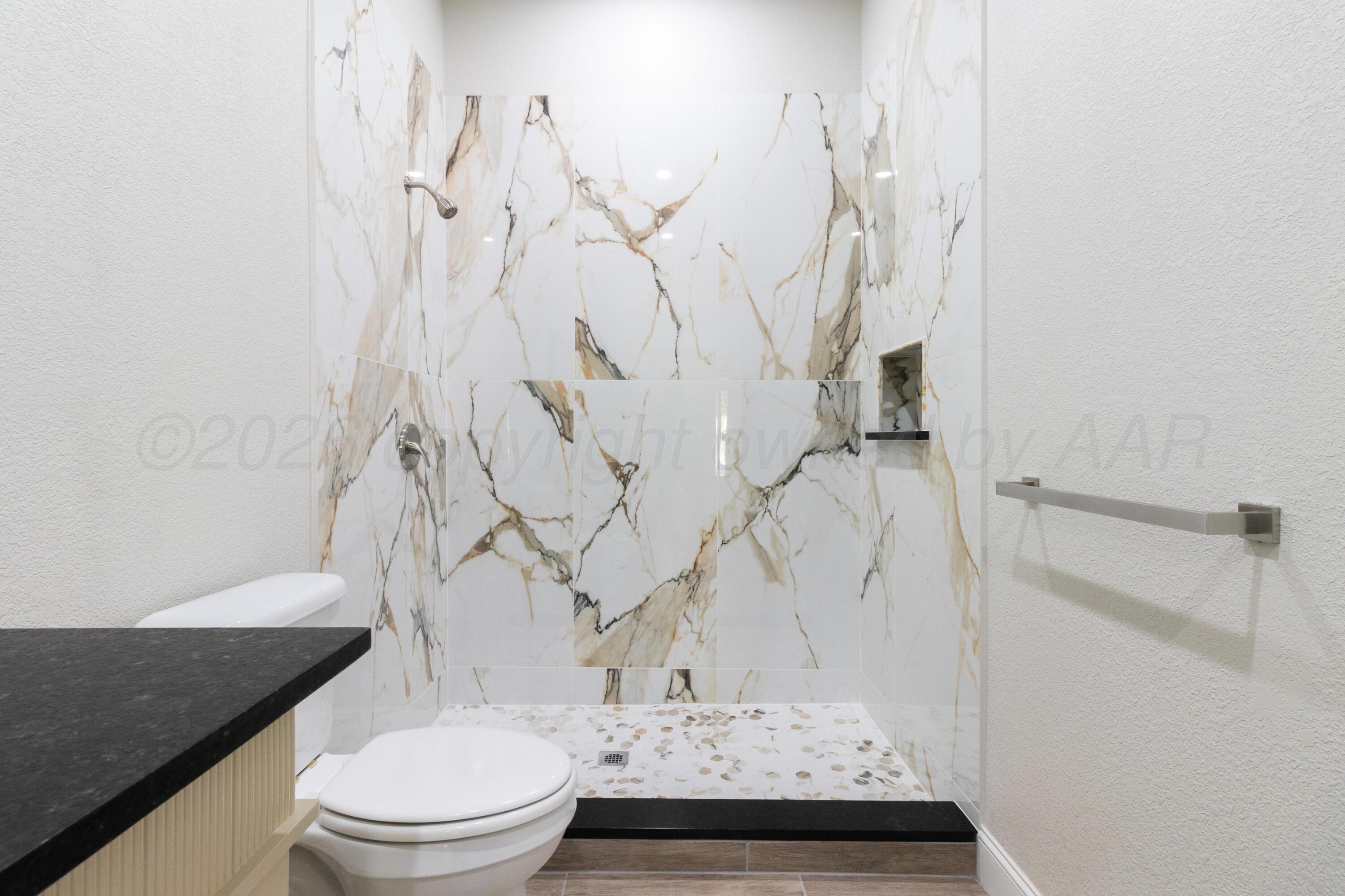 810 South Houston Street Shamrock, TX 79079 - Photo 27 of 42 a bathroom with a granite countertop sink toilet and shower