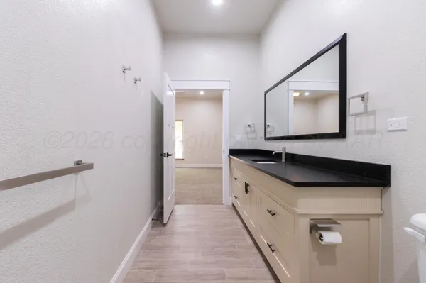 a large white kitchen with a sink and dishwasher a stove with wooden floor