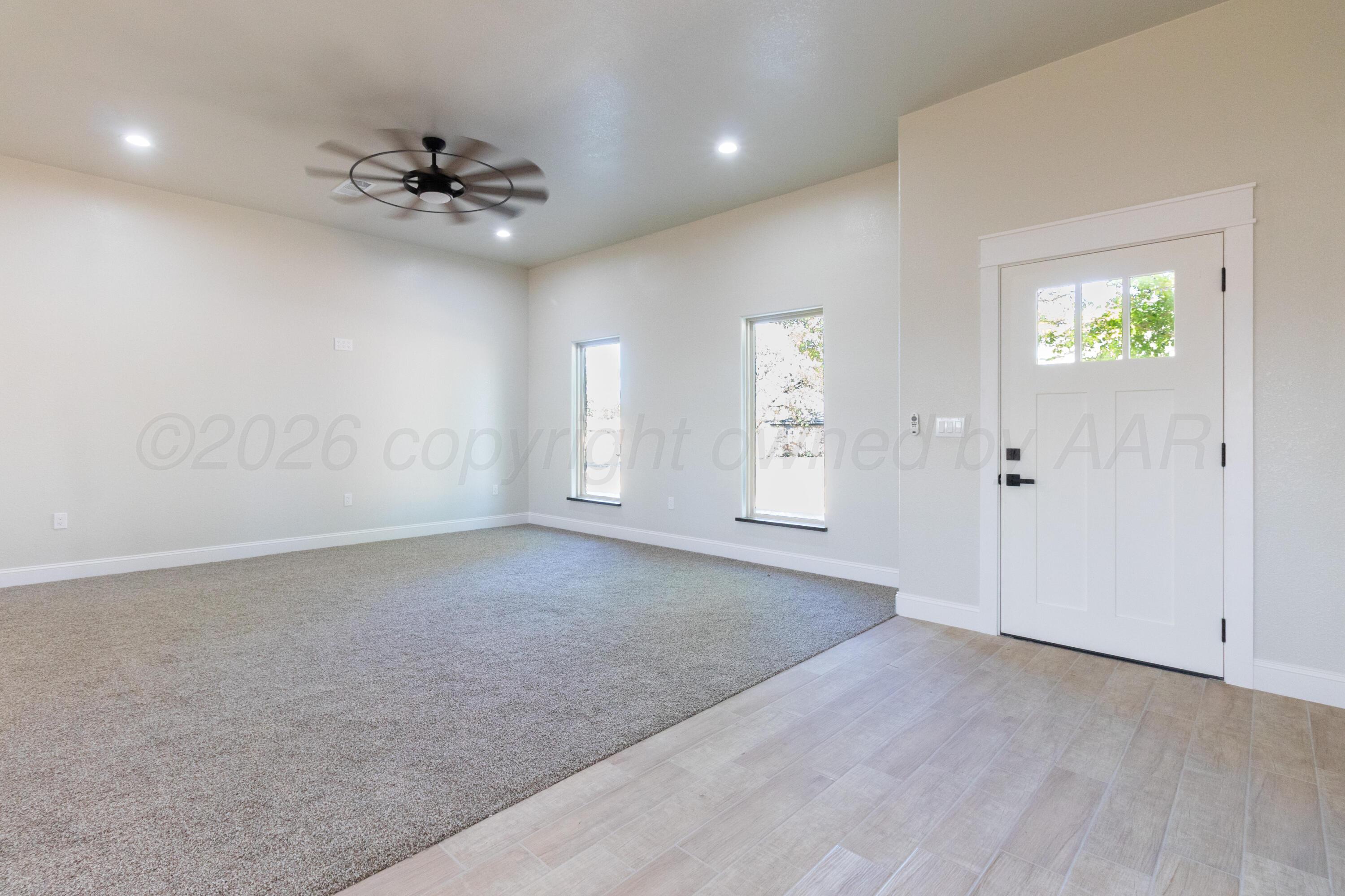 810 South Houston Street Shamrock, TX 79079 - Photo 7 of 42 an empty room with chandelier fan and windows