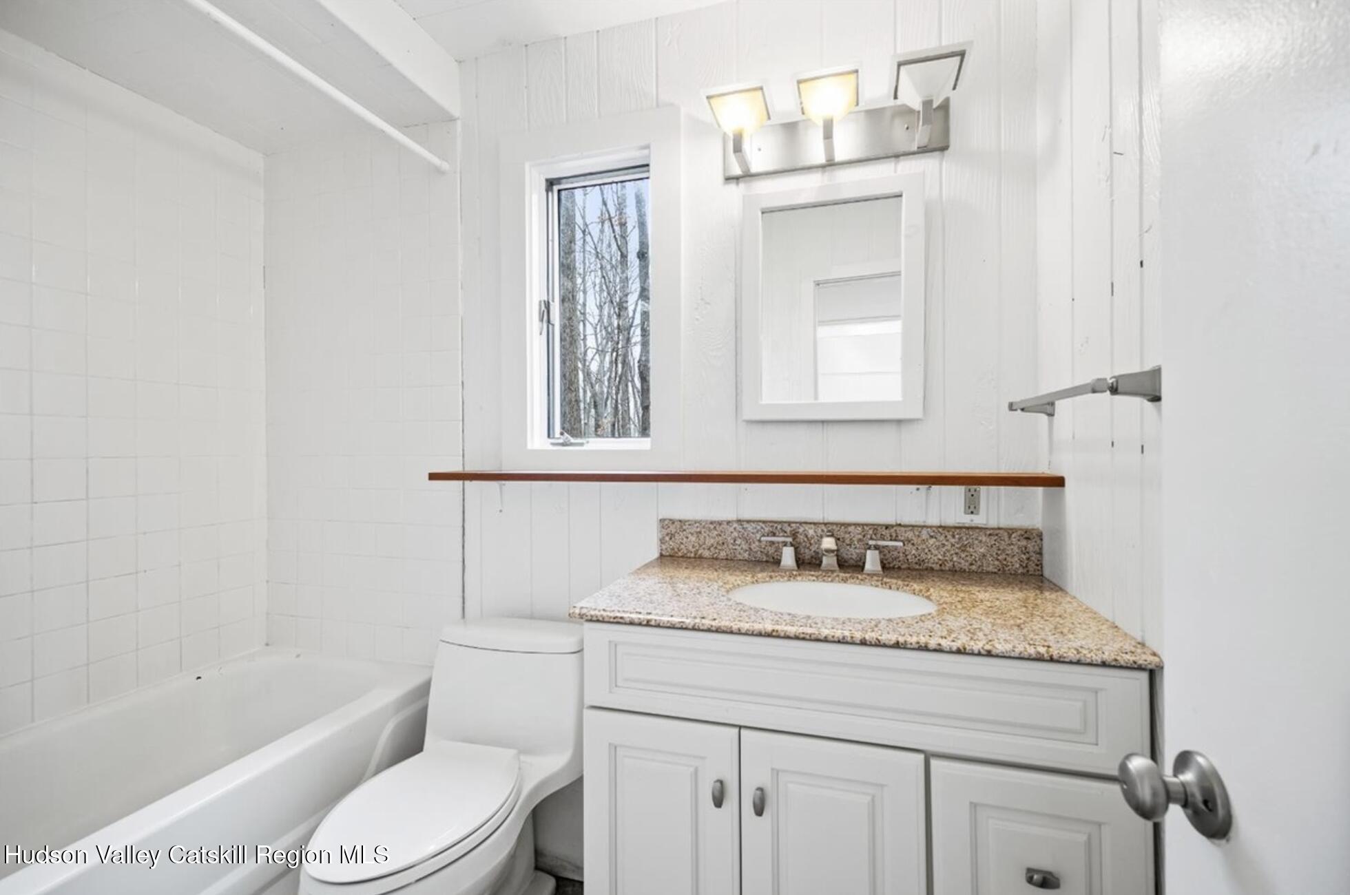 41 Pond Hill Road Copake, NY 12521 - Photo 16 of 25 a bathroom with a granite countertop sink toilet a mirror and bathtub
