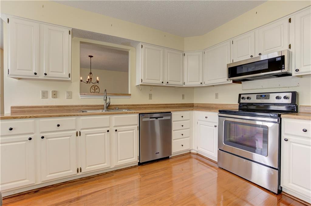 94 Robyn Way Marietta, GA 30062 - Photo 17 of 40 a kitchen with stainless steel appliances granite countertop a sink a stove and cabinets