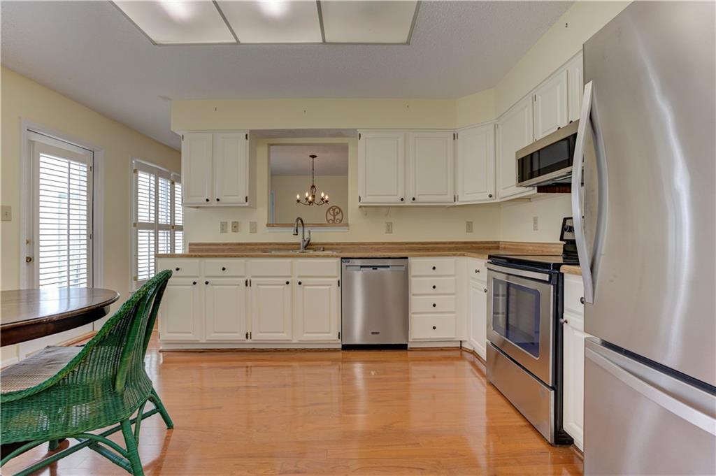 94 Robyn Way Marietta, GA 30062 - Photo 21 of 40 a kitchen with stainless steel appliances kitchen island granite countertop a stove a sink and white cabinets