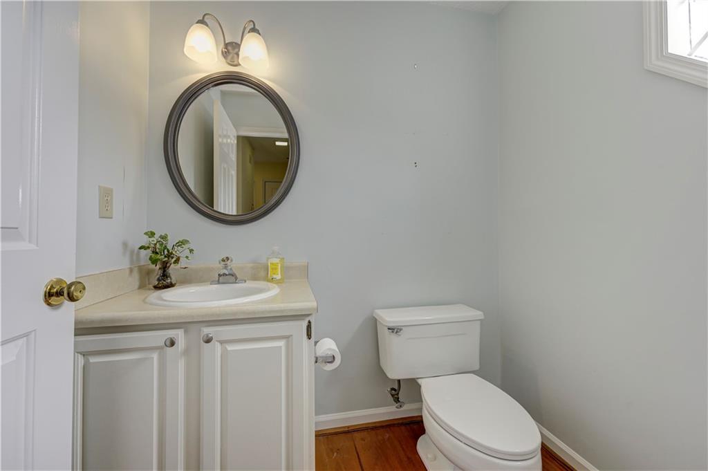94 Robyn Way Marietta, GA 30062 - Photo 22 of 40 a bathroom with a granite countertop toilet a sink and a mirror