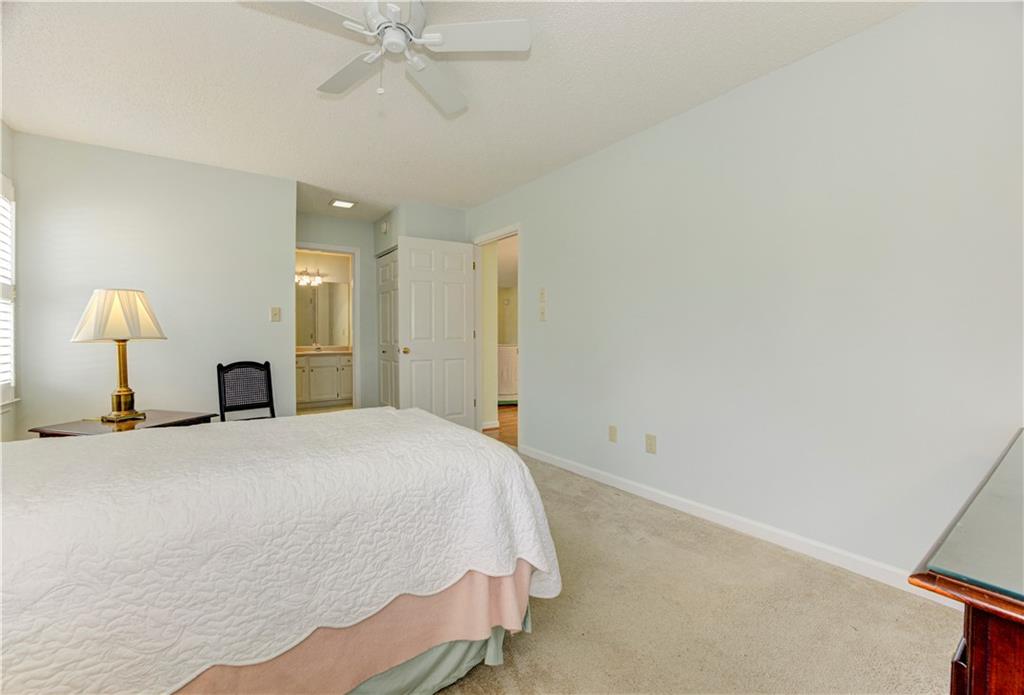 94 Robyn Way Marietta, GA 30062 - Photo 31 of 40 a spacious bedroom with a bed and a chandelier