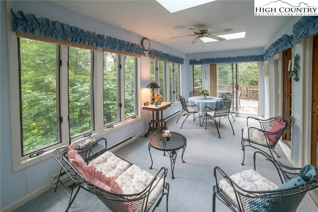 a living room with fireplace furniture and a large window