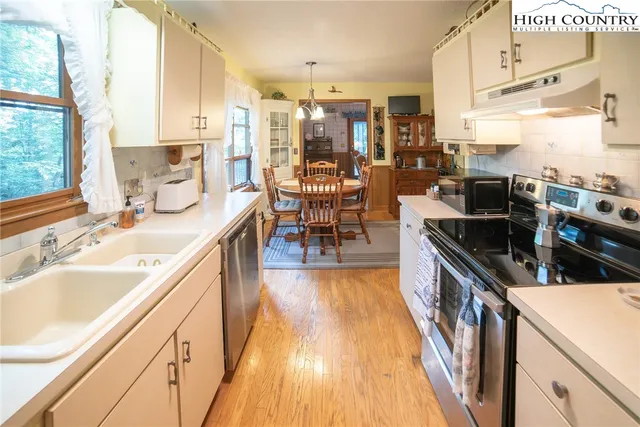 a kitchen with granite countertop a sink a counter top space and stainless steel appliances