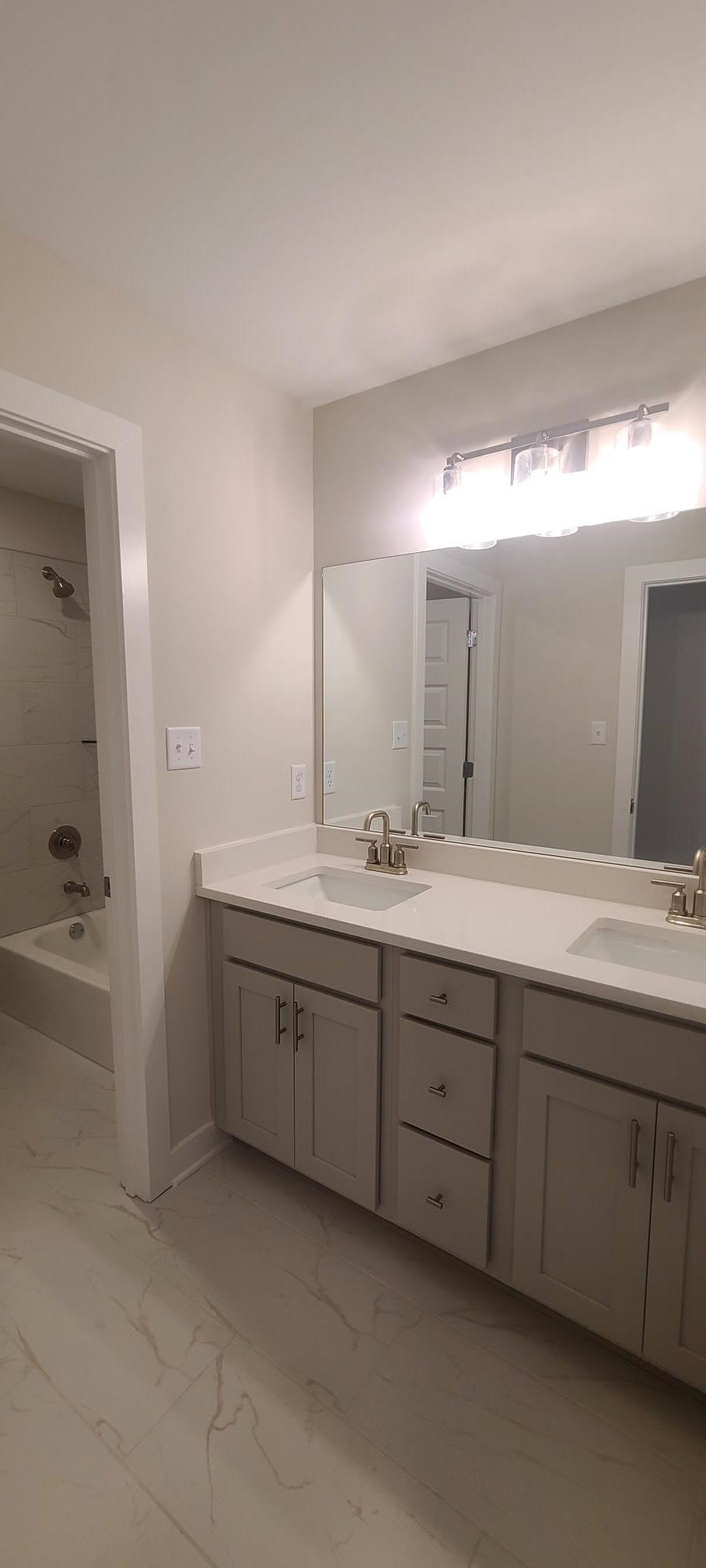 501 Halle Park Drive Collierville, TN 38017 - Photo 30 of 37 a bathroom with double vanity sink and mirror with bathtub
