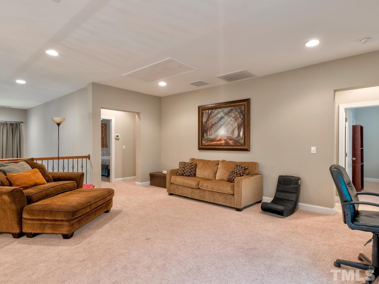 8325 Henderson Road Apex, NC 27539 - Photo 14 of 29 a living room with furniture and a flat screen tv