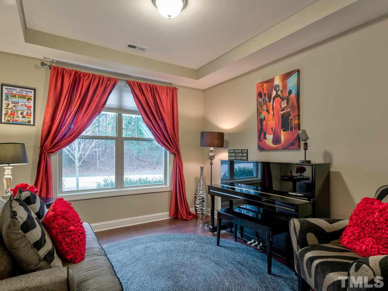 8325 Henderson Road Apex, NC 27539 - Photo 3 of 29 a living room with furniture and a floor to ceiling window