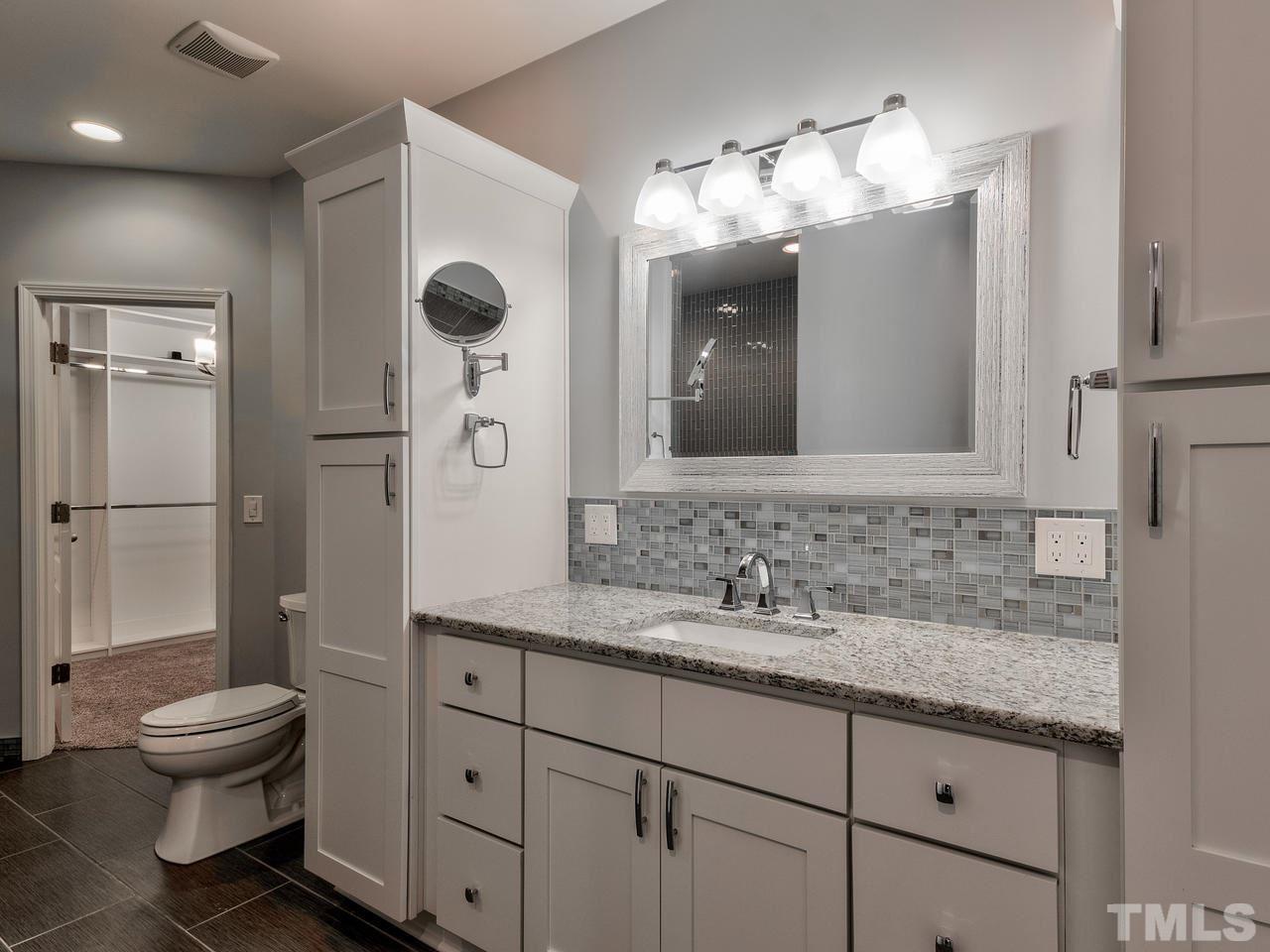 8325 Henderson Road Apex, NC 27539 - Photo 22 of 29 a bathroom with a toilet sink and mirror