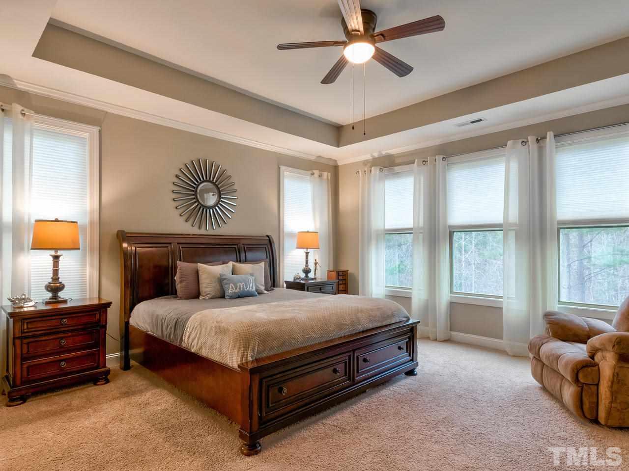 8325 Henderson Road Apex, NC 27539 - Photo 10 of 29 a bedroom with a bed and a large window
