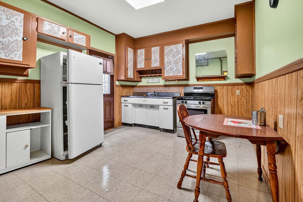 1023 Philadelphia Street Indiana, PA 15701 - Photo 12 of 40 a kitchen with a refrigerator a stove a sink and a dining table with wooden cabinet