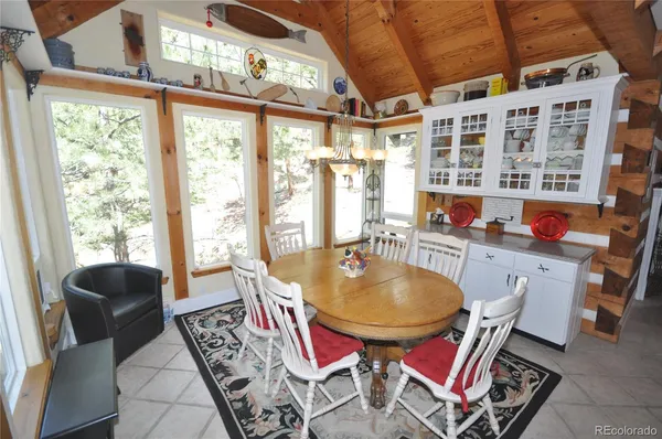 a dining room with furniture a rug and a floor to ceiling window