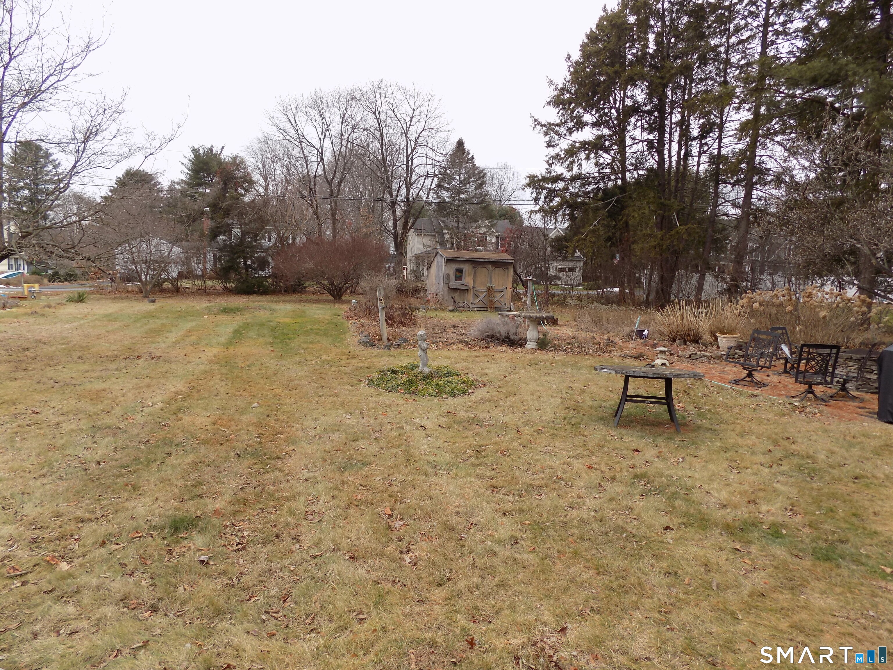 a view of backyard with wooden fence and large trees