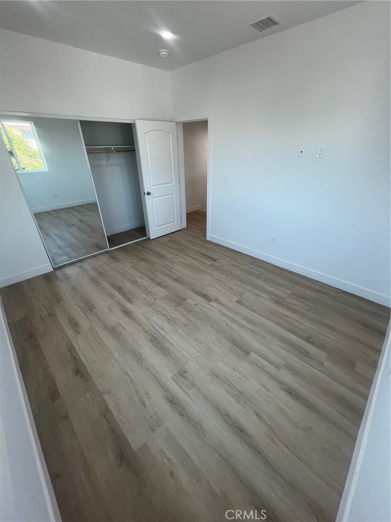 1128 South Ardmore Avenue Los Angeles, CA 90006 - Photo 12 of 30 an empty room with wooden floor and windows
