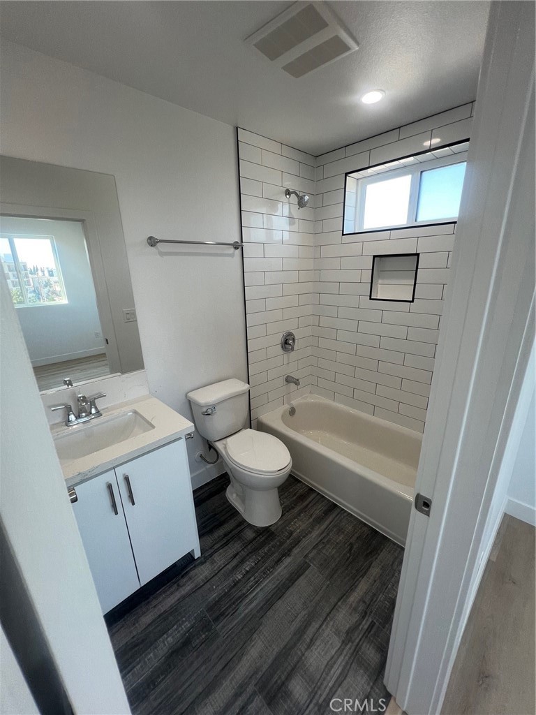 1128 South Ardmore Avenue Los Angeles, CA 90006 - Photo 15 of 30 a bathroom with a granite countertop sink toilet a mirror and shower