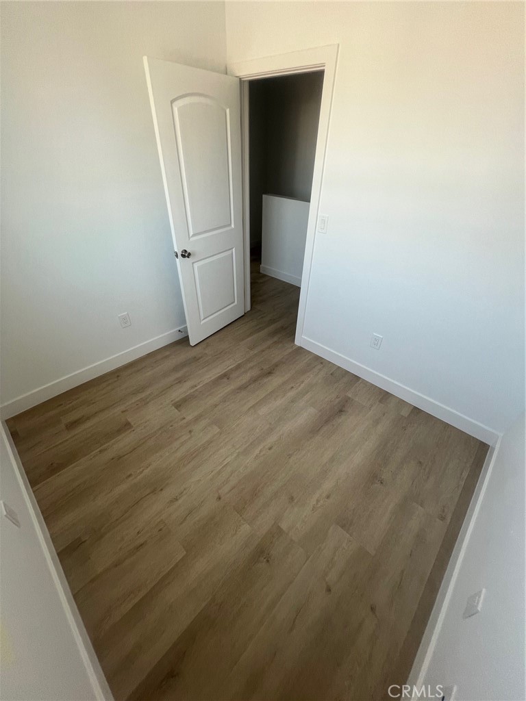 1128 South Ardmore Avenue Los Angeles, CA 90006 - Photo 22 of 30 an empty room with wooden floor and mirror