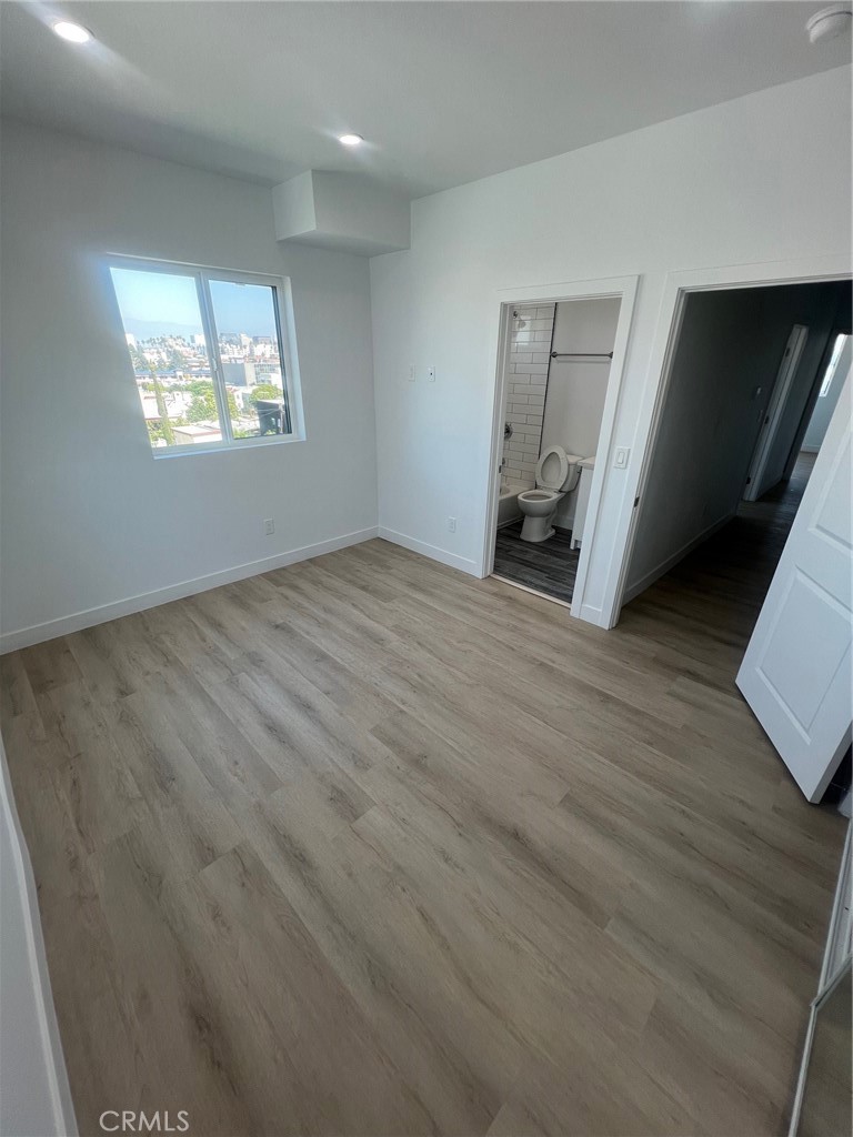 1128 South Ardmore Avenue Los Angeles, CA 90006 - Photo 23 of 30 a view of an empty room with wooden floor and a window