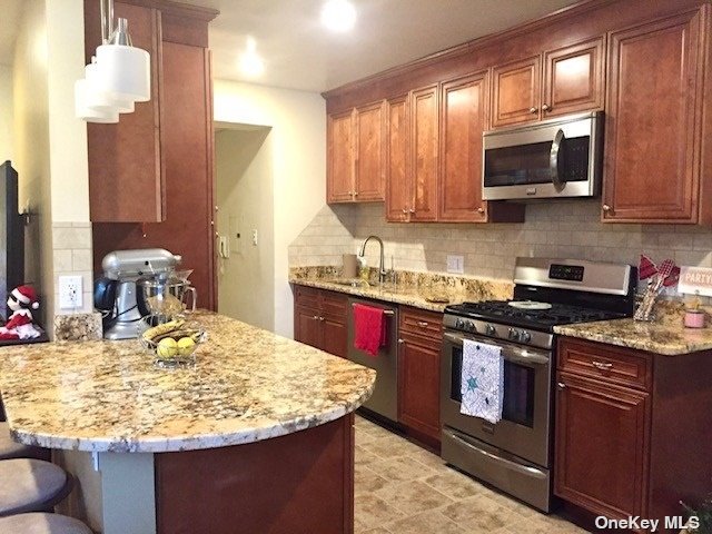 a kitchen with kitchen island granite countertop a sink stove and microwave