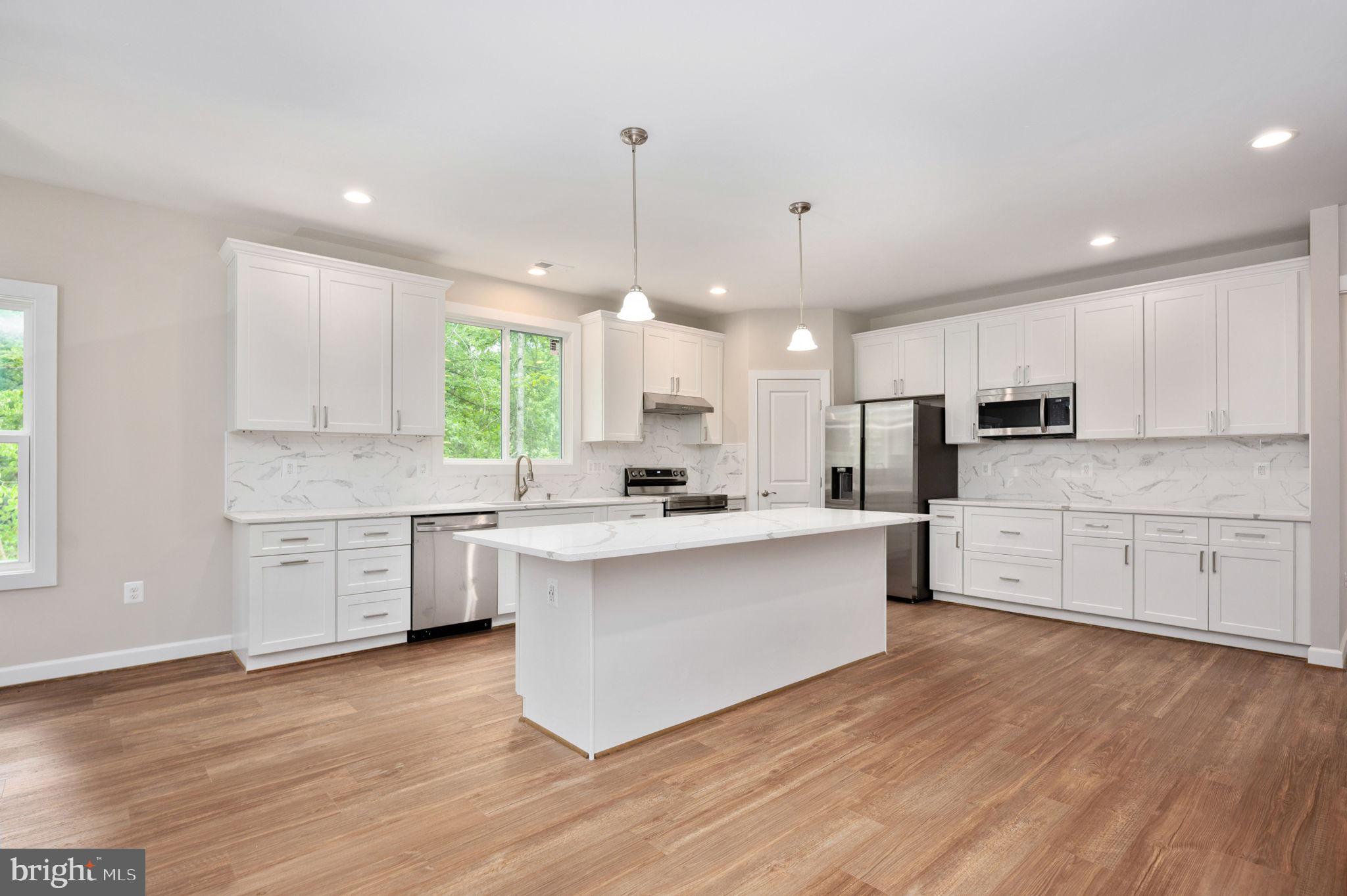 107 Gold Valley Road Locust Grove, VA 22508 - Photo 5 of 19 a large kitchen with cabinets wooden floor and stainless steel appliances