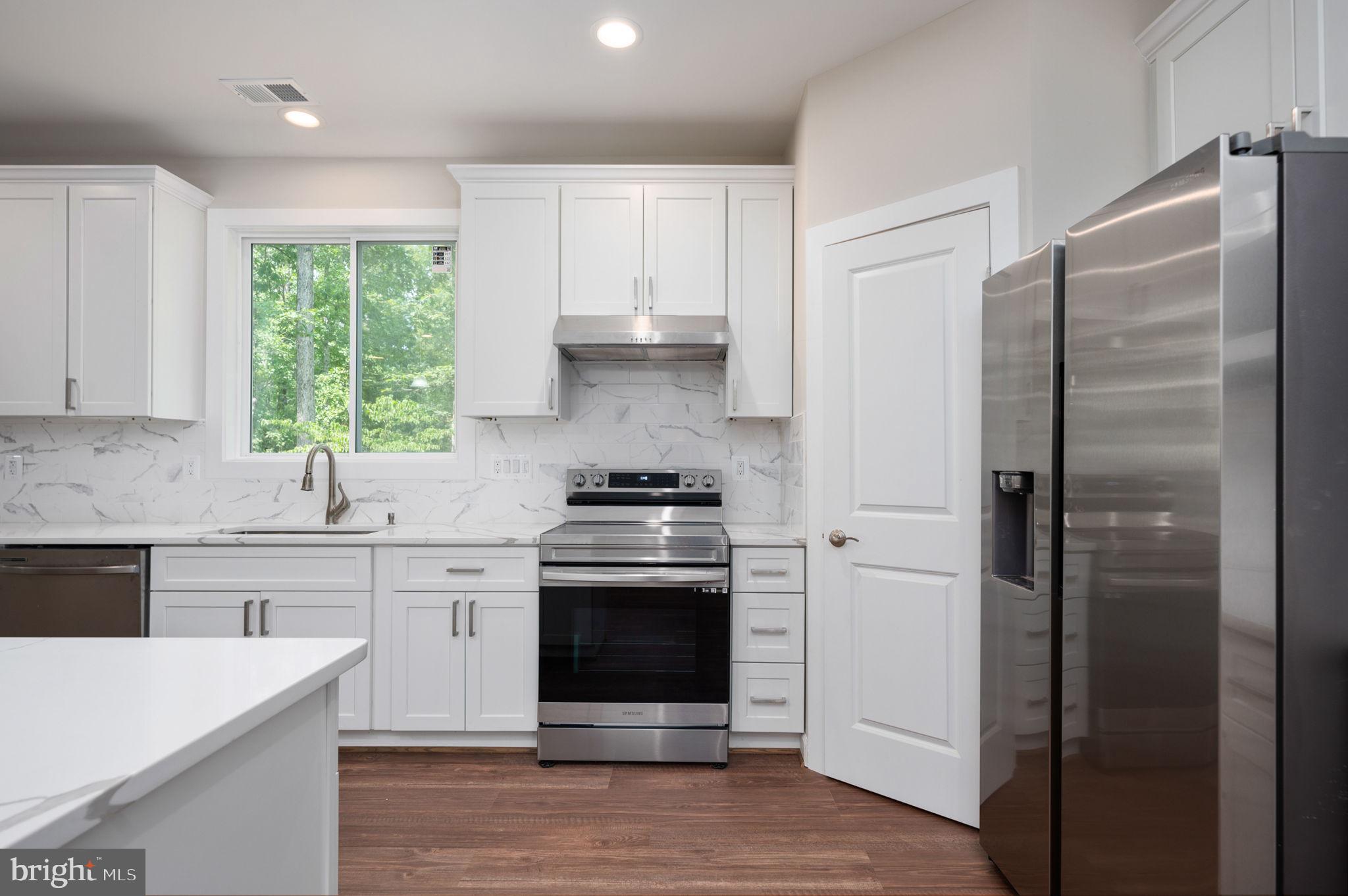 107 Gold Valley Road Locust Grove, VA 22508 - Photo 8 of 19 a kitchen with stainless steel appliances white cabinets and a refrigerator