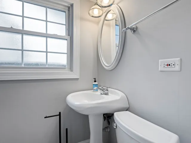 a bathroom with a toilet sink and a mirror