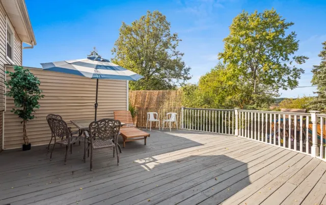 a balcony with wooden floor table and chairs