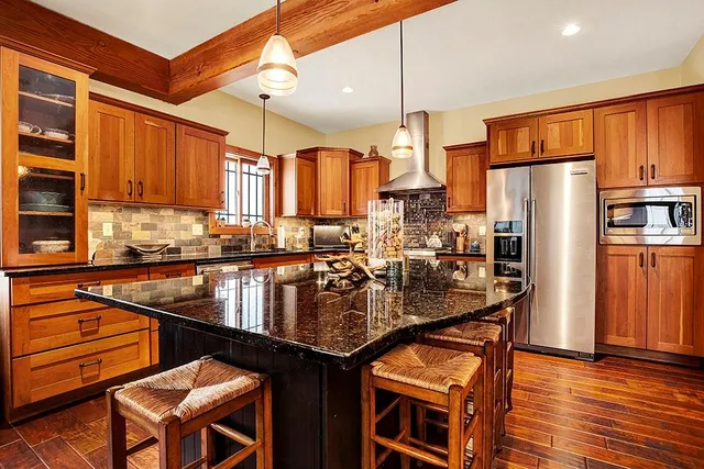 a kitchen with stainless steel appliances granite countertop a refrigerator a sink and a stove