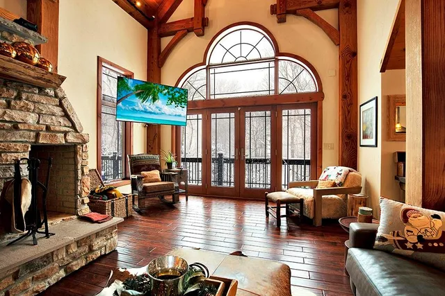 a living room with furniture a fireplace and wooden floor