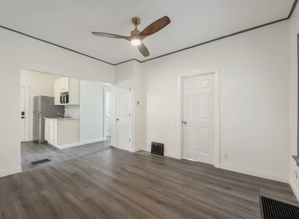 a view of empty room with wooden floor