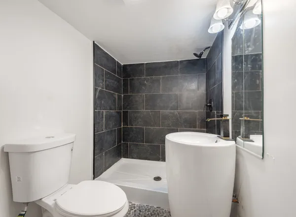 a bathroom with a toilet a sink and shower