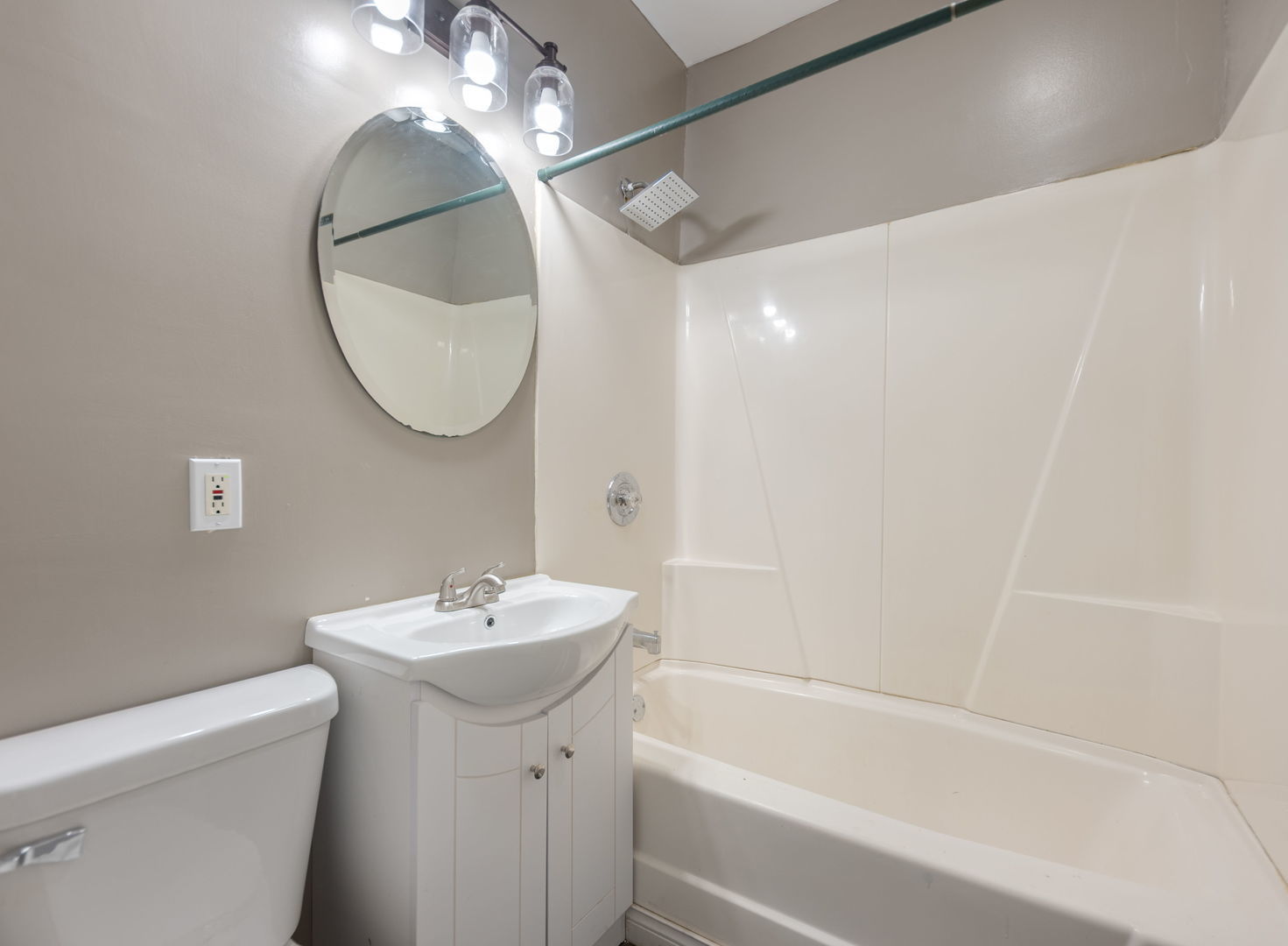 312 West Stone Street Kankakee, IL 60901 - Photo 7 of 17 a bathroom with a sink a mirror and a bathtub