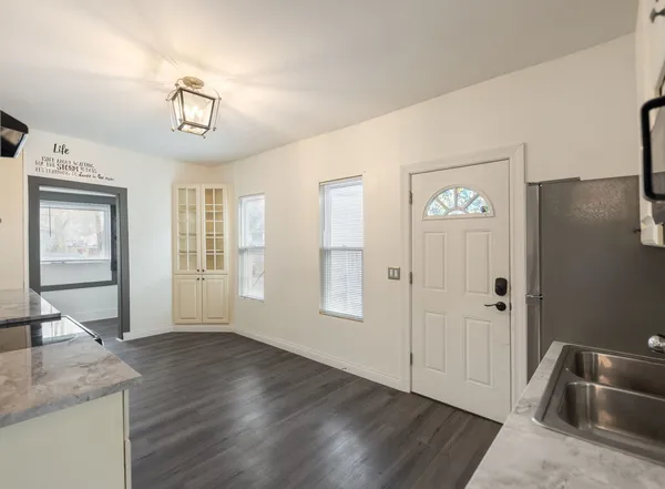 a view of a livingroom with wooden floor and kitchen space