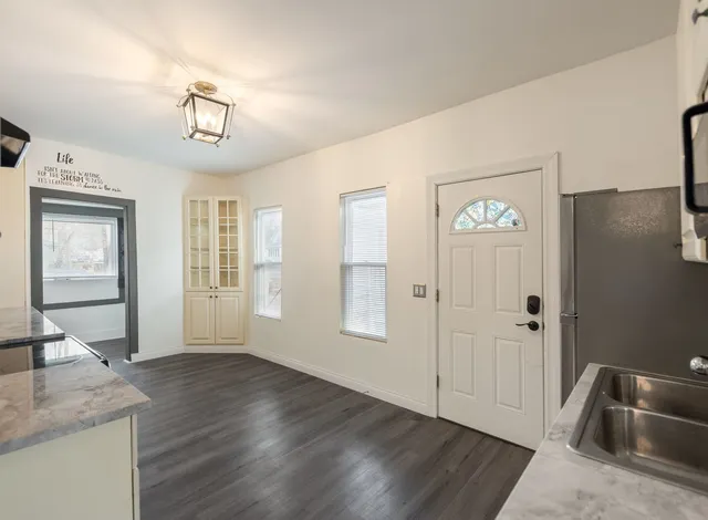 a view of a livingroom with wooden floor and kitchen space