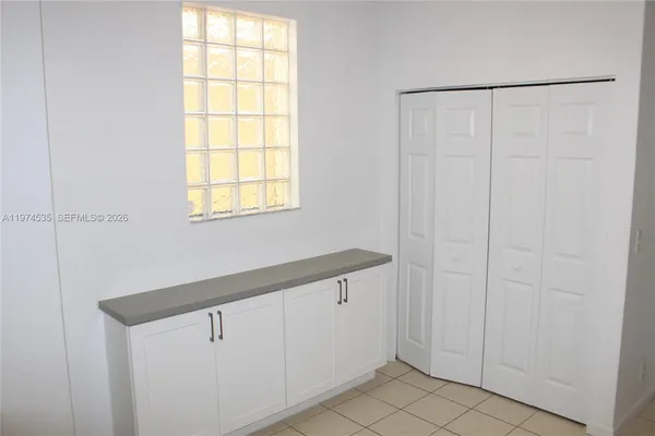 a kitchen with white cabinets and appliances