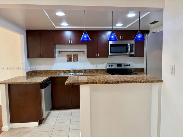 a kitchen with stainless steel appliances granite countertop a sink and a microwave