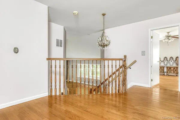 a view of empty room with wooden floor and window