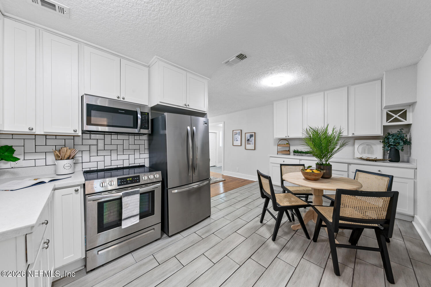 715 Ralph Street Jacksonville, FL 32204 - Photo 8 of 21 a kitchen with stainless steel appliances a stove a refrigerator a dining table and chairs