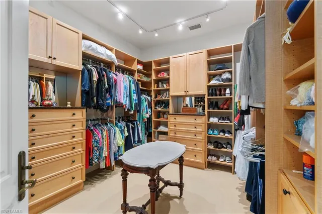 a view of walk in closet with clothes and shoes