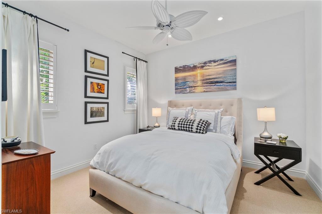 29150 Positano Lane Naples, FL 34110 - Photo 18 of 50 a bedroom with a bed and a chandelier