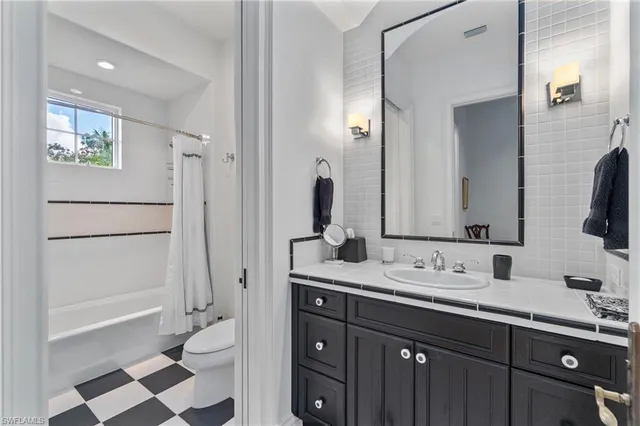 a bathroom with a double vanity sink toilet and shower