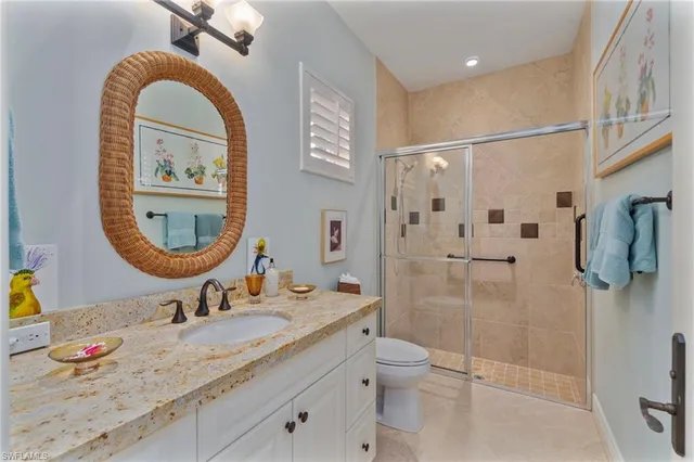a bathroom with a granite countertop sink mirror toilet and shower