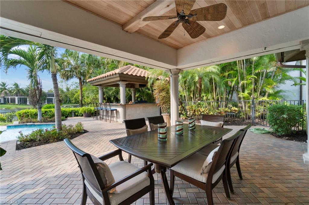 29150 Positano Lane Naples, FL 34110 - Photo 29 of 50 a view of a patio with a table chairs and a backyard