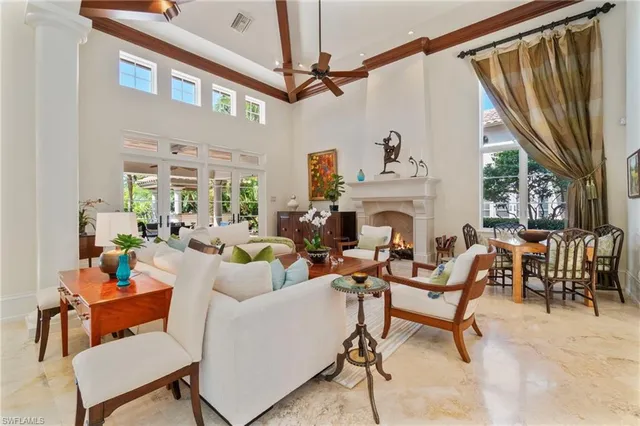 a living room with furniture a fireplace and a floor to ceiling window