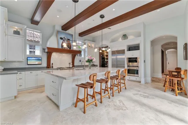 a kitchen with stainless steel appliances kitchen island granite countertop a table and chairs in it