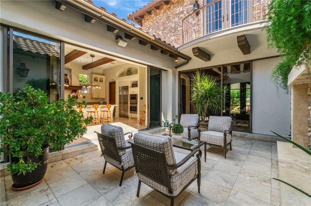 29150 Positano Lane Naples, FL 34110 - Photo 8 of 50 a view of a patio with couches table and chairs and potted plants