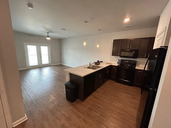 a kitchen with stainless steel appliances kitchen island granite countertop a stove top oven and sink