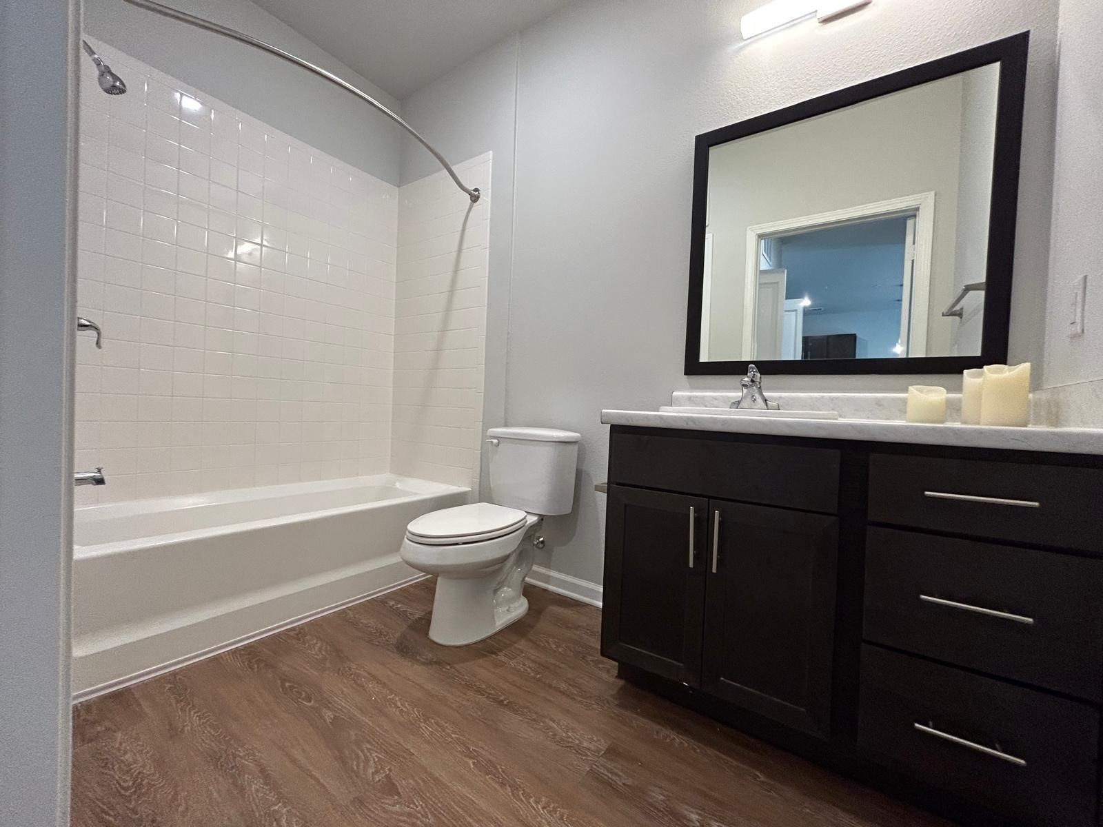 2136 West 34th Street, Unit 135 Houston, TX 77018 - Photo 4 of 8 a bathroom with a toilet a sink a mirror and a bathtub