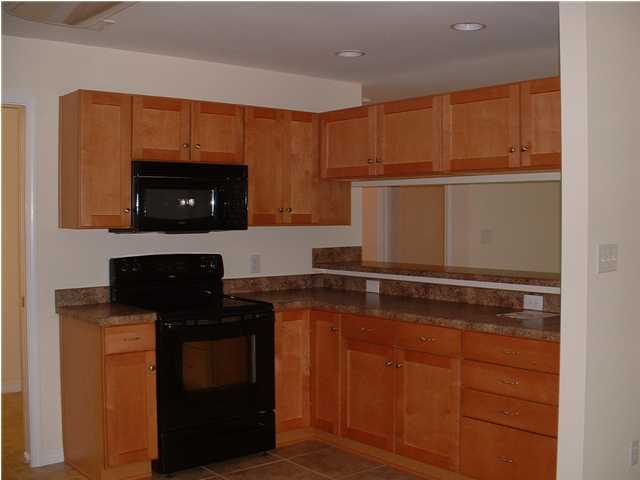 119 North 3rd Street Santa Rosa Beach, FL 32459 - Photo 15 of 18 a kitchen with granite countertop stainless steel appliances and wooden cabinets